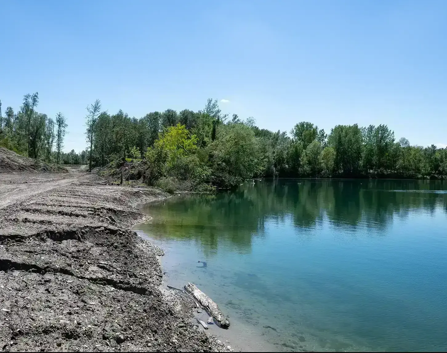 Ufer bei Abwinden-Asten: Das Ufer ist gesäumt von unterschiedlichen großen Bäumen und man sieht auf der linken Seite bereits erste Spuren der Baustelle.