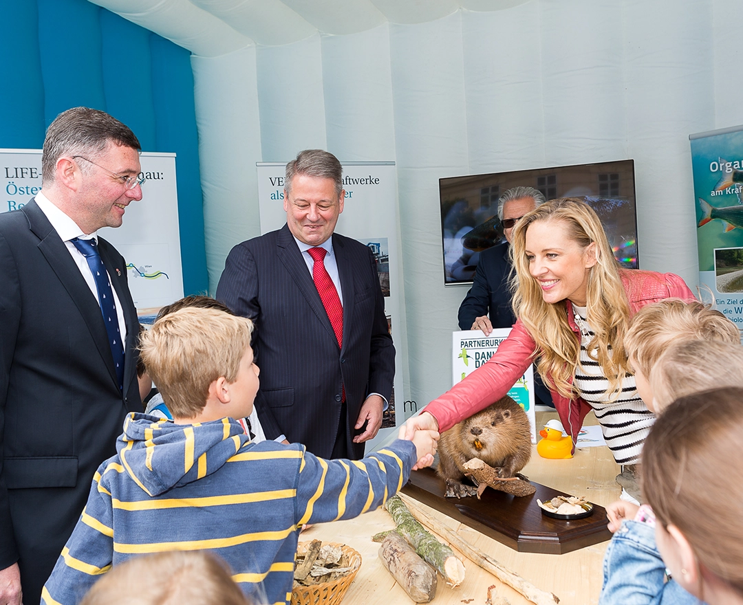 At Danubeday 2019 you could find out about the Danube habitat. The picture shows interested adults and children. A blonde woman shakes a boy's hand.